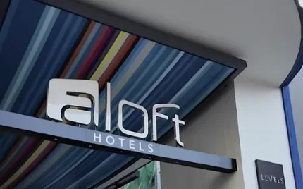 カラフルな天井の下にあるaloft HOTELSのサイン