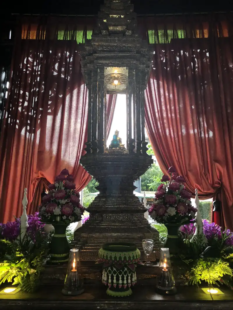 赤いカーテンと花に囲まれた、ろうそくの灯る祭壇