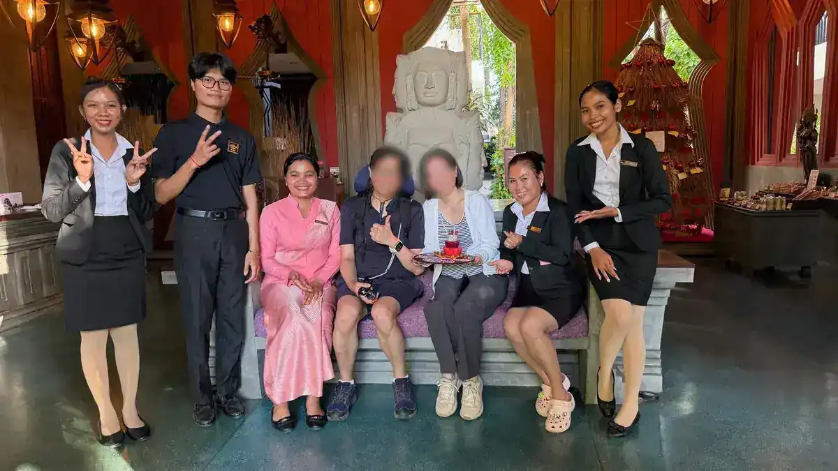 ロビーの石像の前で、スタッフの皆さんと誕生日のケーキを囲んだ記念写真