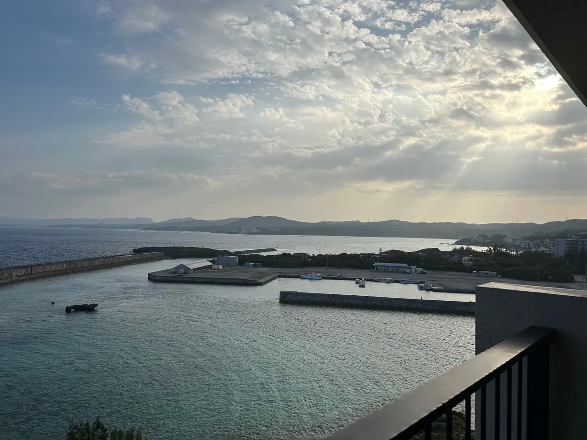 バルコニーから見た、港と光が差し込む雲の空