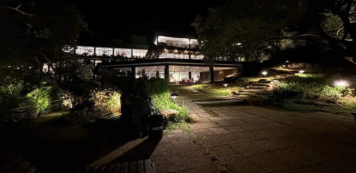夜、ライトアップされたホテルの建物と庭の小道
