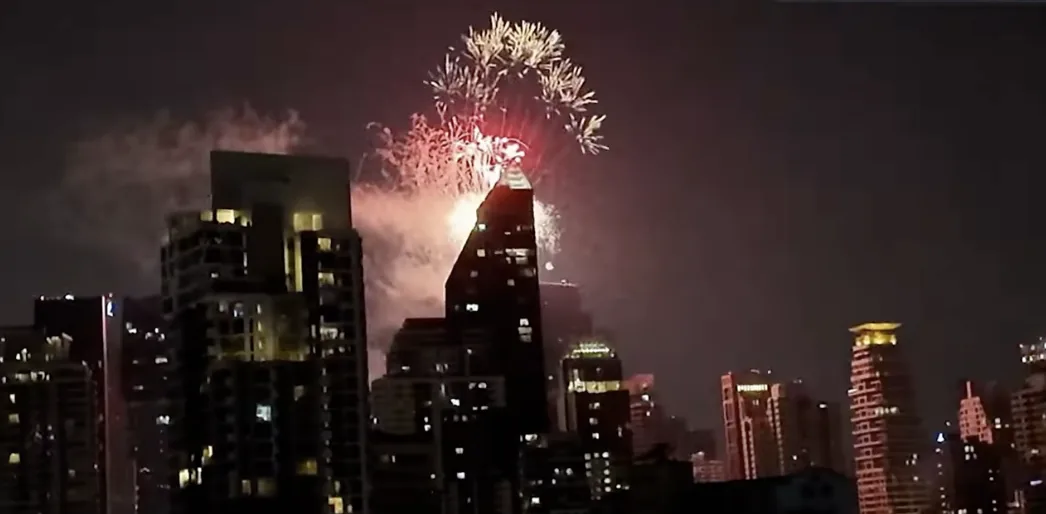 高層ビルの向こうに打ち上がる年越しの花火