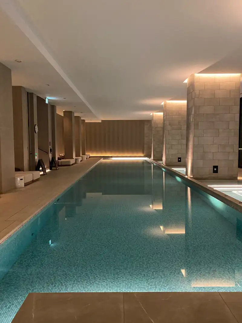 間接照明に照らされた、細長い屋内プール
