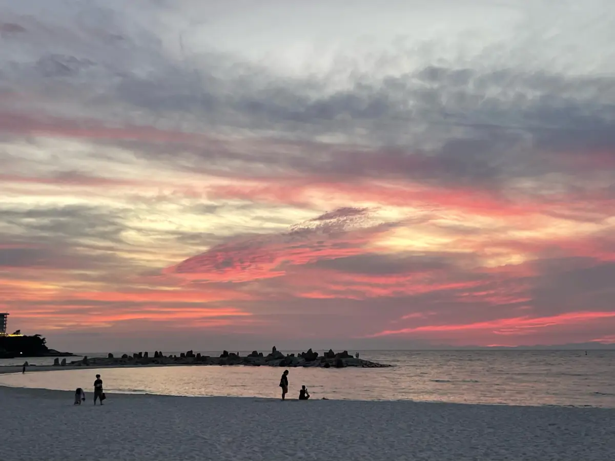 夕焼けに染まる白良浜の空と海
