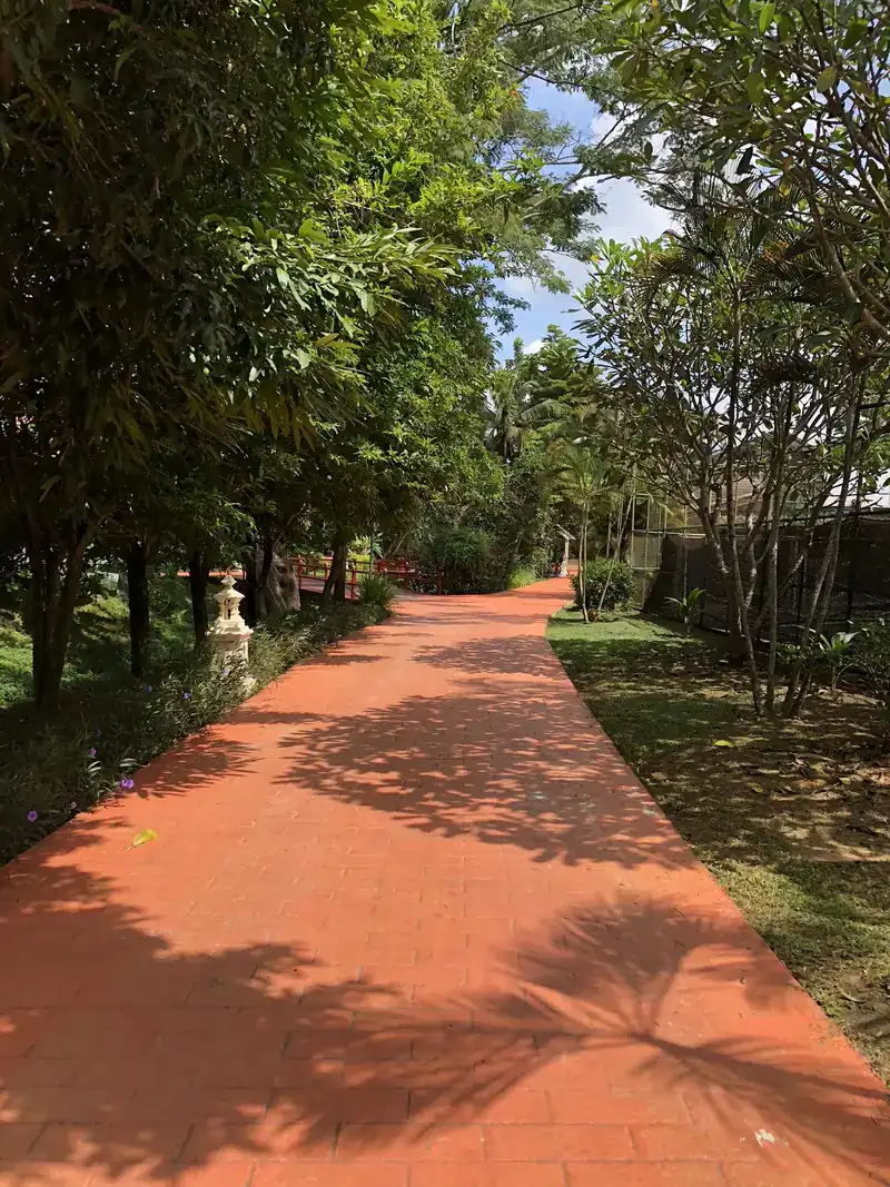 木々に囲まれた赤いレンガの散歩道