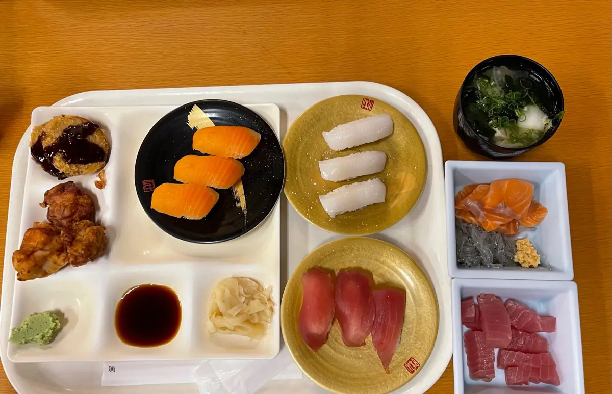 まぐろやサーモンの握り、刺身、から揚げなどを並べたトレー